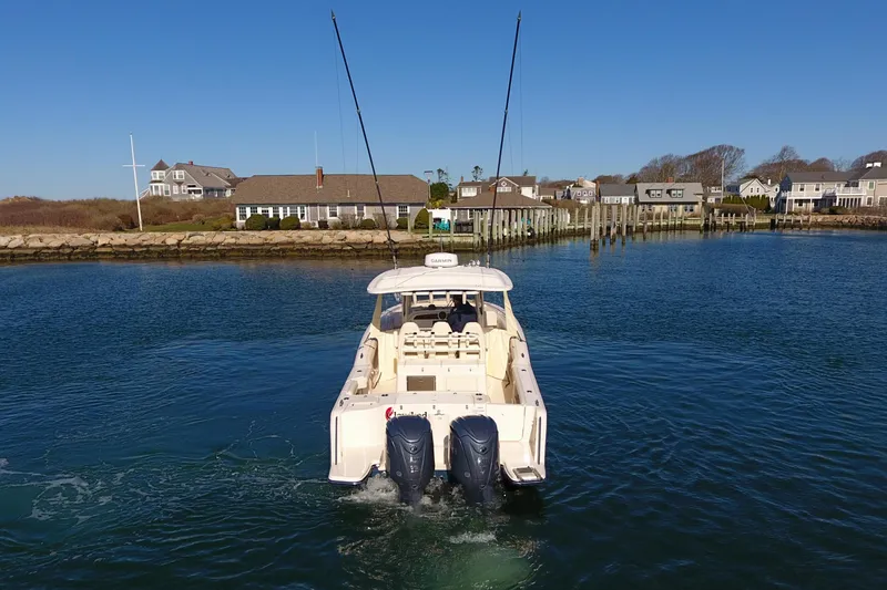  Yacht Photos Pics 2022 Grady-White Canyon 326 boat cruising in a scenic coastal area.