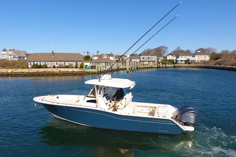  Yacht Photos Pics 2022 Grady-White Canyon 326 boat cruising in a scenic coastal area.