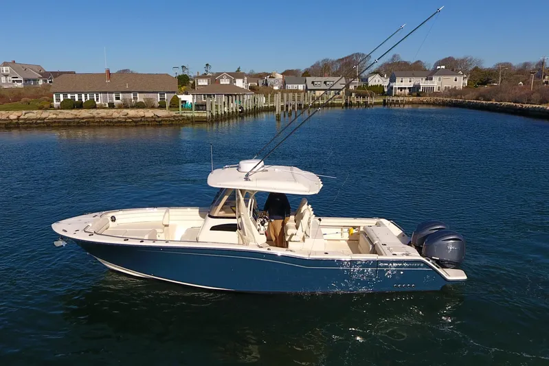  Yacht Photos Pics 2022 Grady-White Canyon 326 boat on calm water near coastal homes.