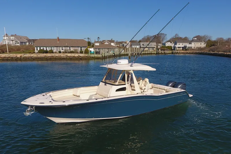  Yacht Photos Pics 2022 Grady-White Canyon 326 boat on calm water near coastal homes.