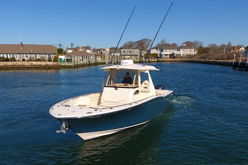  Yacht Photos Pics 2022 Grady-White Canyon 326 boat cruising in a scenic coastal area.