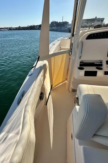  Yacht Photos Pics 2022 Grady-White Canyon 326 boat interior with seating and control panel, docked on calm water.