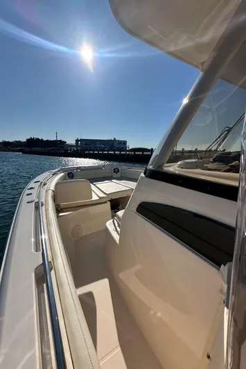  Yacht Photos Pics 2022 Grady-White Canyon 326 boat under sunny sky, docked near water.