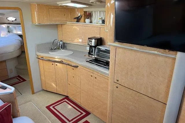 Knot For Sail Yacht Photos Pics 1997 Sea Ray 450 Sundancer interior kitchen with wood cabinets, sink, and appliances.