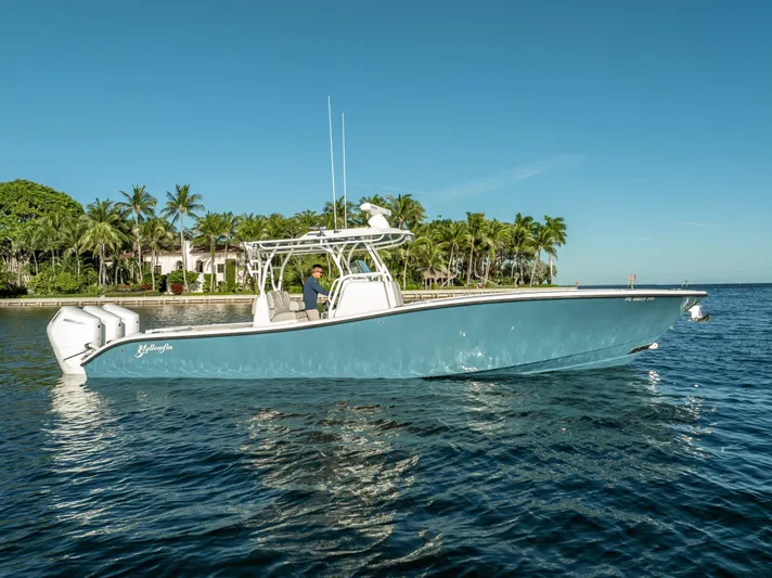  Yacht Photos Pics 2023 Yellowfin 36 boat on water, clear sky, palm trees in background.