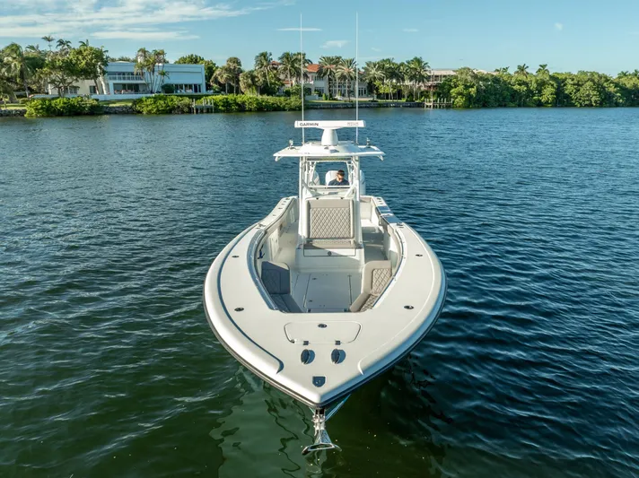  Yacht Photos Pics 2023 Yellowfin 36 boat on calm water with scenic waterfront background.