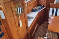Interior of 1987 Zijlmans Kruiser boat with wooden cabinetry and compact kitchen area.