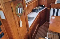 Interior of 1987 Zijlmans Kruiser boat with wooden cabinetry and compact kitchen area.