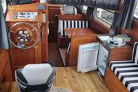 Interior of 1987 Zijlmans Kruiser boat with wooden decor and striped seating.