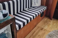 Interior of 1987 Zijlmans Kruiser with striped seating and open mini fridge.