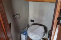 Compact bathroom on 1987 Zijlmans Kruiser boat with toilet and wooden flooring.