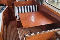 1987 Zijlmans Kruiser interior with wooden dining area and striped seating.