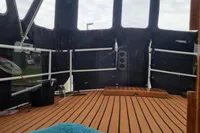 Interior view of 1987 Zijlmans Kruiser boat with wooden deck and blue towel.
