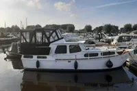 1987 Zijlmans Kruiser boat docked in a marina under a partly cloudy sky.