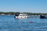 1987 Zijlmans Kruiser boat docked on a serene lake with swimmers nearby.