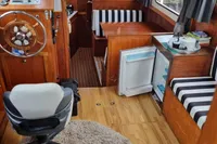 Interior of a 1987 Zijlmans Kruiser boat with wooden furnishings and striped seating.