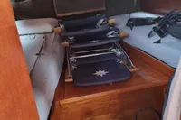 Interior of 1987 Zijlmans Kruiser boat cabin with beds and folded chairs.