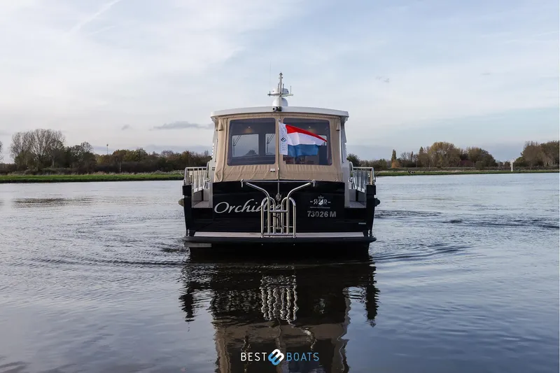  Yacht Photos Pics Linssen Grand Sturdy 470 Wheelhouse 2017 on calm water, rear view with flag.