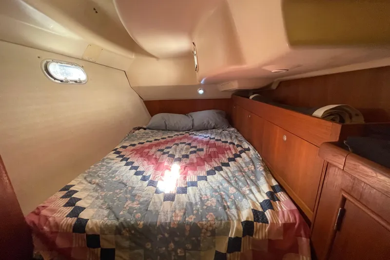  Yacht Photos Pics Cozy cabin interior of 1999 Hunter 460 sailboat with quilted bedspread.