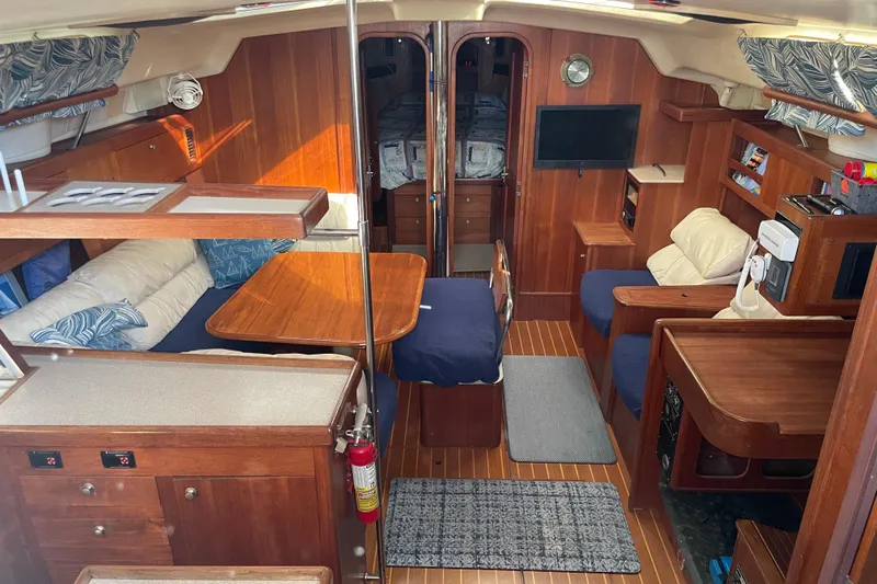  Yacht Photos Pics Cozy interior of a 1999 Hunter 460 sailboat with wood finish and seating area.