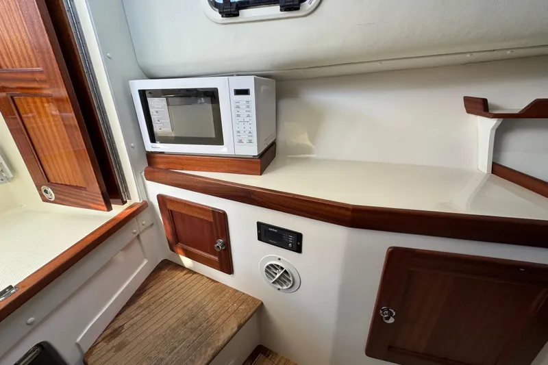  Yacht Photos Pics Interior of 2026 NorthCoast 285 HT boat with microwave and wooden cabinetry.