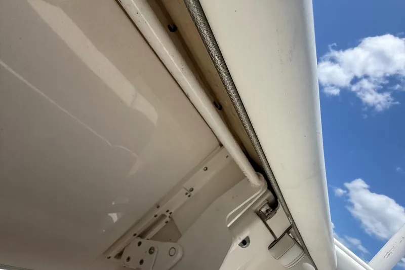  Yacht Photos Pics Close-up of a 2014 Jupiter 30 FS boat detail against a blue sky with clouds.