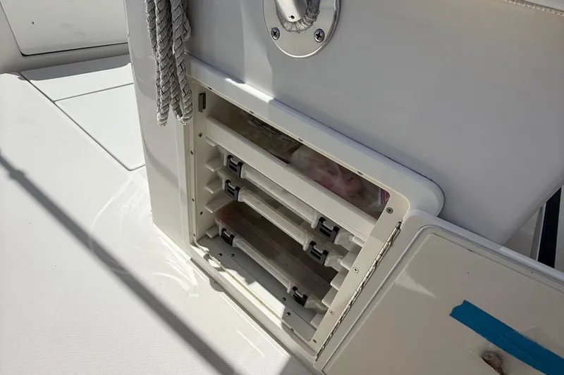  Yacht Photos Pics Open storage compartment on a 2014 Jupiter 30 FS boat, featuring organized trays and ropes.