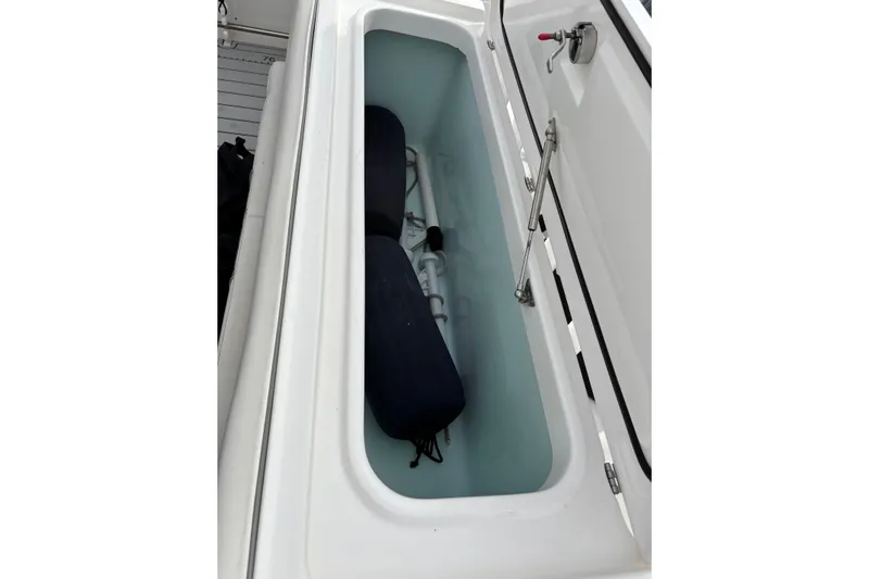 Liberty Call Yacht Photos Pics Storage compartment on a 2015 Edgewater 320CC boat, featuring cushions and hydraulic lift.