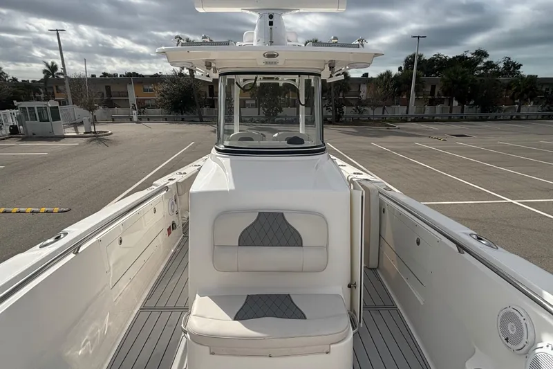Liberty Call Yacht Photos Pics 2015 Edgewater 320CC boat interior with seating, parked in an empty lot.
