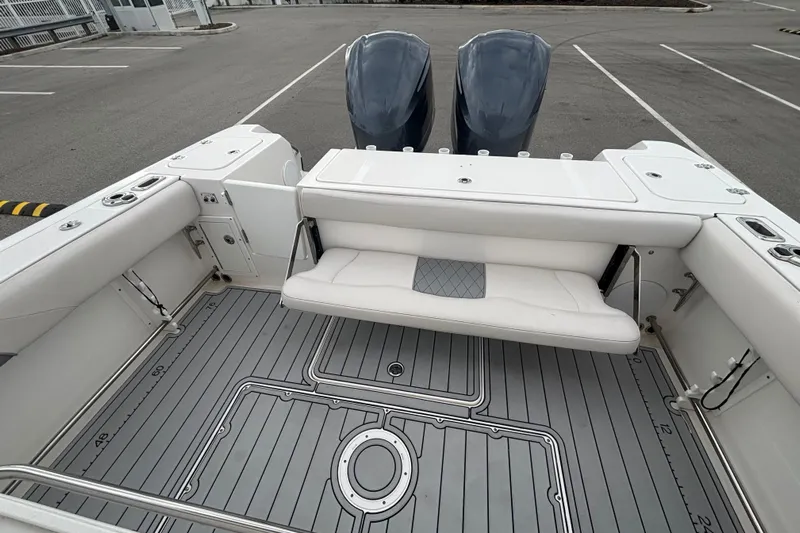 Liberty Call Yacht Photos Pics 2015 Edgewater 320CC boat interior with seating and dual engines in a parking area.