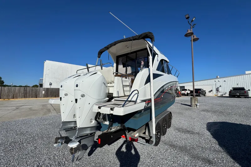  Yacht Photos Pics 2020 Beneteau Antares 27 boat on trailer, dual engines, parked outdoors under clear blue sky.