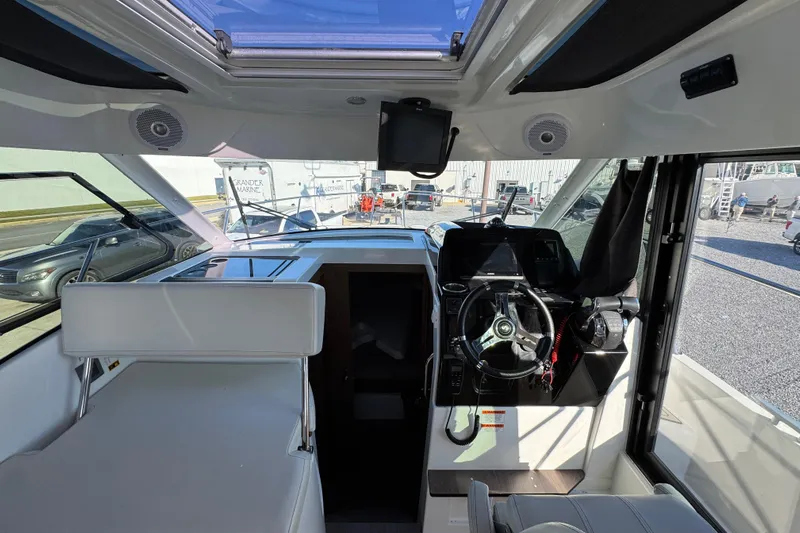  Yacht Photos Pics Interior view of 2020 Beneteau Antares 27 boat cockpit with steering wheel and seating.
