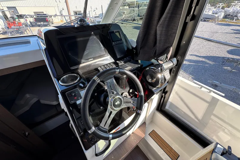  Yacht Photos Pics Helm station of 2020 Beneteau Antares 27 with steering wheel and navigation controls.