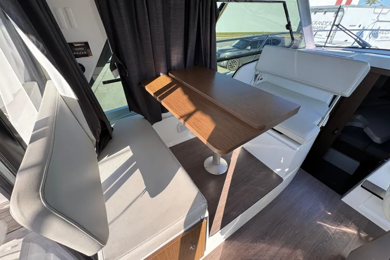  Yacht Photos Pics Interior of 2020 Beneteau Antares 27 with seating and wooden table.