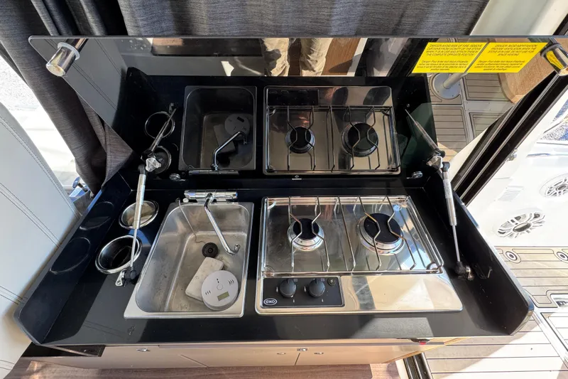  Yacht Photos Pics 2020 Beneteau Antares 27 kitchen with stove and sink, compact and modern design.