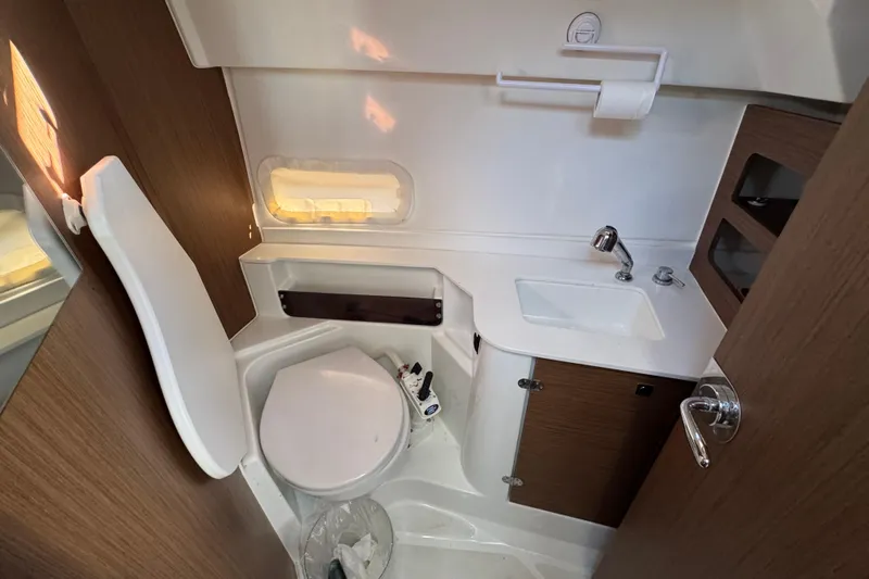 Yacht Photos Pics Beneteau Antares 27 bathroom interior, featuring a compact toilet and sink, 2020 model.