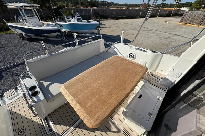  Yacht Photos Pics 2020 Beneteau Antares 27 boat deck with seating and wooden table.
