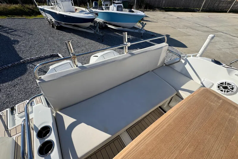  Yacht Photos Pics Beneteau Antares 27 (2020) boat interior with seating and table, docked outdoors.