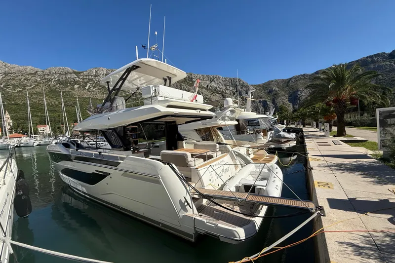 Ava Hana Yacht Photos Pics Luxurious 2024 Prestige F4.9 yacht docked in a scenic marina with mountain backdrop.
