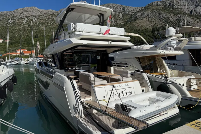 Ava Hana Yacht Photos Pics Luxury 2024 Prestige F4.9 yacht docked in scenic marina with mountainous backdrop.