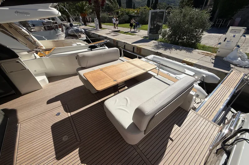 Ava Hana Yacht Photos Pics 2024 Prestige F4.9 yacht deck with seating and wooden table, docked at marina.