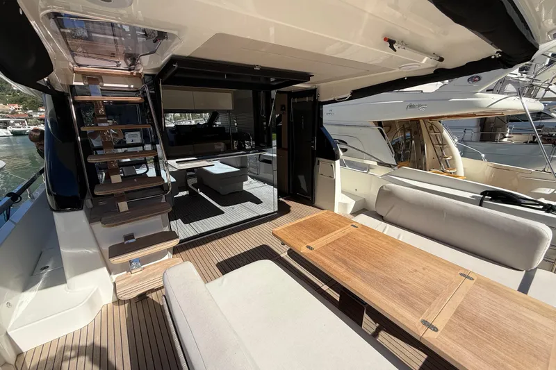 Ava Hana Yacht Photos Pics Luxurious 2024 Prestige F4.9 yacht interior with elegant seating and wooden table.