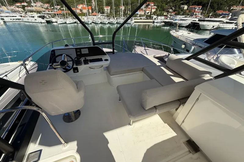 Ava Hana Yacht Photos Pics 2024 Prestige F4.9 yacht cockpit with helm, seating, and marina view.