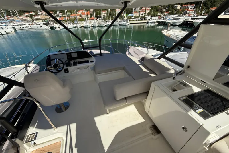 Ava Hana Yacht Photos Pics 2024 Prestige F4.9 yacht flybridge with helm, seating, and marina view.
