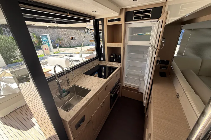 Ava Hana Yacht Photos Pics Modern kitchen interior of 2024 Prestige F4.9 yacht with open fridge and sleek design.