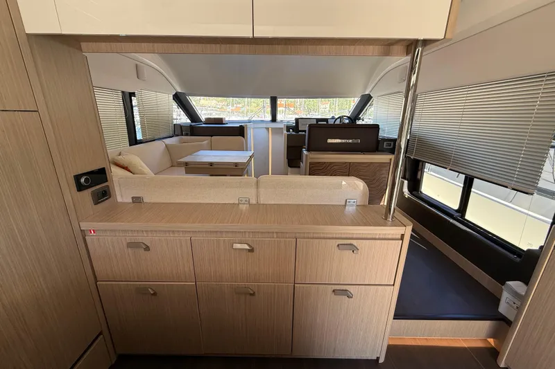 Ava Hana Yacht Photos Pics Modern interior of 2024 Prestige F4.9 yacht with sleek wood cabinetry and spacious seating area.