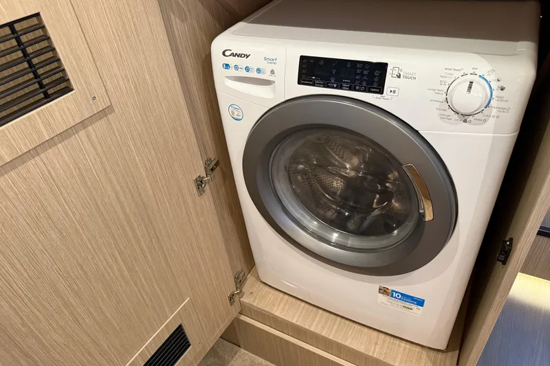 Ava Hana Yacht Photos Pics 2024 Prestige F4.9 washing machine in wooden cabinet, featuring digital controls and front-loading design.