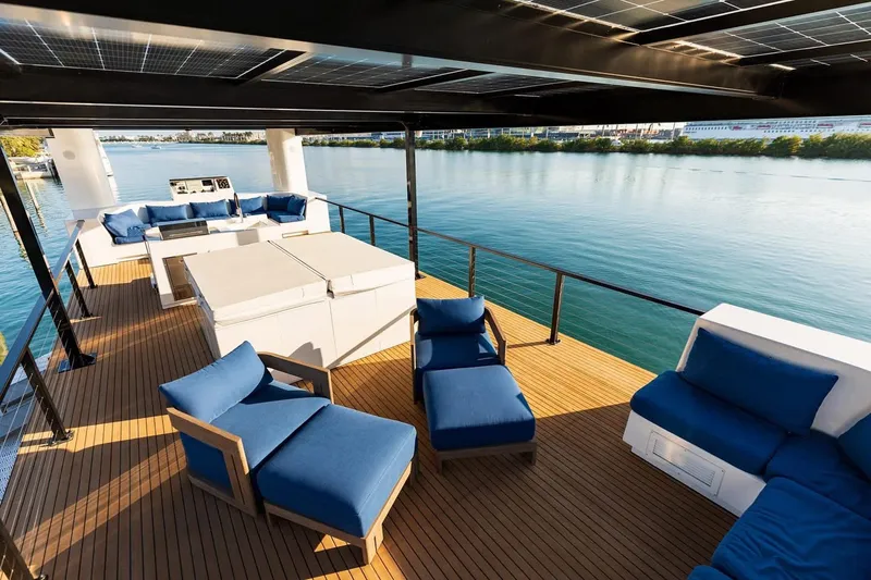  Yacht Photos Pics Luxurious deck of 2025 Custom Arkup 50 with blue seating and waterfront view.