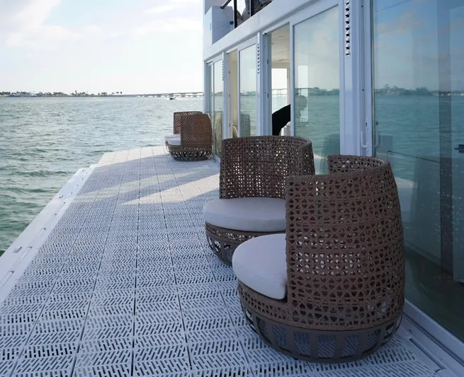  Yacht Photos Pics Floating deck of Arkup 50 houseboat with wicker chairs, overlooking serene waters.