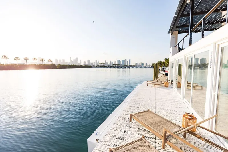  Yacht Photos Pics Modern Arkup 50 houseboat with solar panels, overlooking serene water and city skyline, 2025 model.